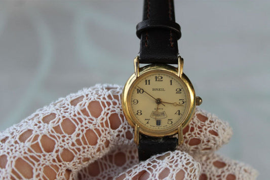 A hyper-realistic editorial photograph featuring the Vintage Breil Watch Steel Leather Custode del Tempo elegantly displayed on a textured antique wooden surface. The watch, with its stainless steel case glinting softly in the chiaroscuro l